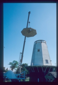 During the course of repairs, a temporary roof is lifted onto the mill to protect the interior from the weather while the cap is repaired at ground level