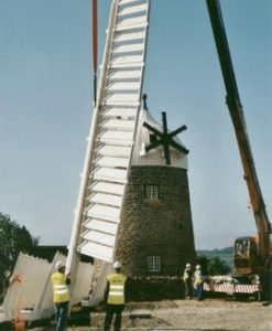 The first sail is lifted in place at Heage Tower Mill