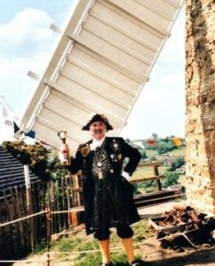 Belper Town Cryer poses by sail of Heage Tower Mill
