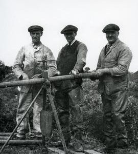 Three men with metal pipe