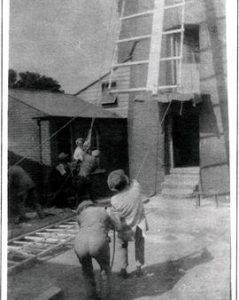 Photograph showing hoisting of sail frame