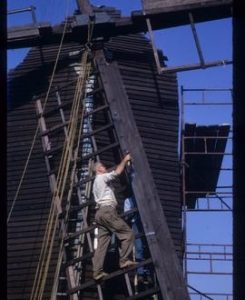 Man working on sails in course of repair, post mill, Nutley