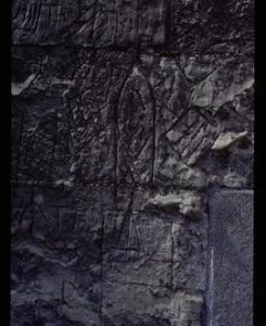 Carving of post mill on wall of church