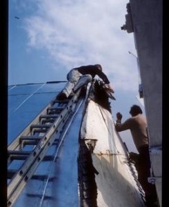 Men working on roof fitting or removing metal sheeting, Jill Mill, Clayton
