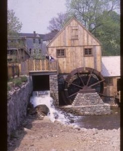 Exterior view of preserved watermill building with wheel