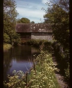 Exterior view of watermill building by river