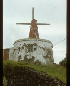 Odd little mill, like miniature smock mill with tailpole, standing on circular brick structure