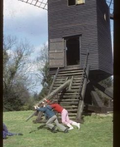 Post mill, Nutley, with visitors pushing on tailpole to turn it into wind