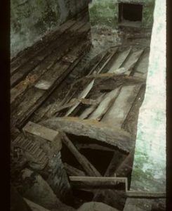Interior of watermill looking down onto top of waterwheel