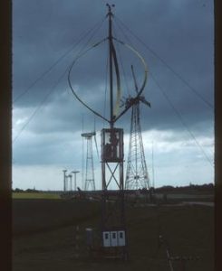 Row of seven modern wind turbines, mostly of propellor type