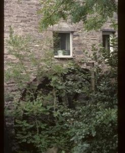 Exterior view of preserved watermill building with wheel