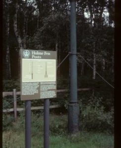 Iron column with information board beside it on "Holme Fen Posts"