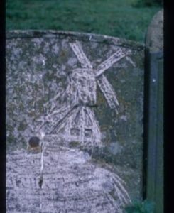 Tombstone with carving of post mill