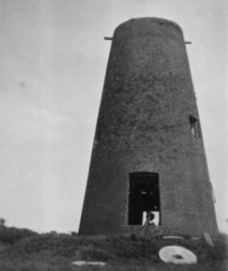 Gutted tower with millstone outside, tower mill, Wootton