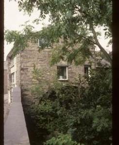 Exterior view of preserved watermill building with wheel