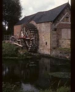 Exterior of preserved watermill building with wheel