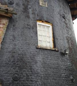 Detail of brickwork of tower, tower mill, Caston; note 1864 datestone