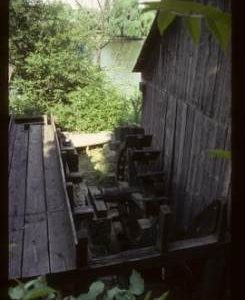 Exterior of preserved watermill building with wheel