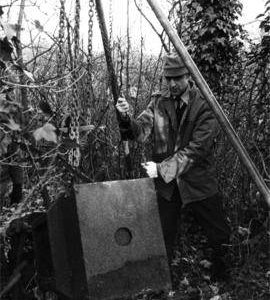 Iron canister being recovered from undergrowth, Billericay Mill, Great Burstead