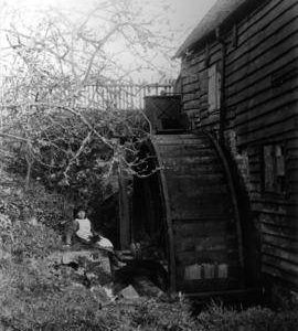Detail view of waterwheel with posed girl, Whitley Mill, Chevening